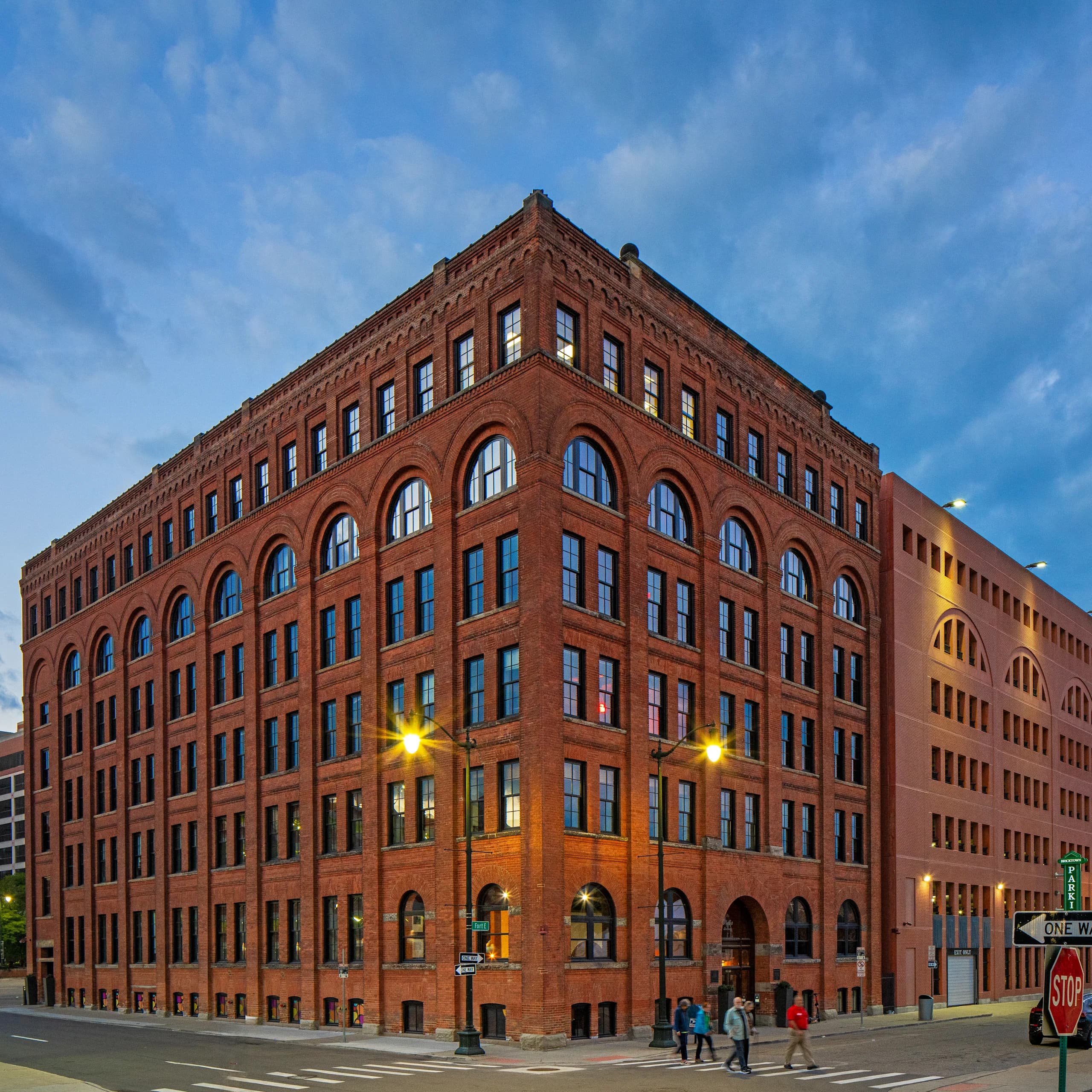 Exterior view of The Globe building in downtown Detroit with people walking across the street