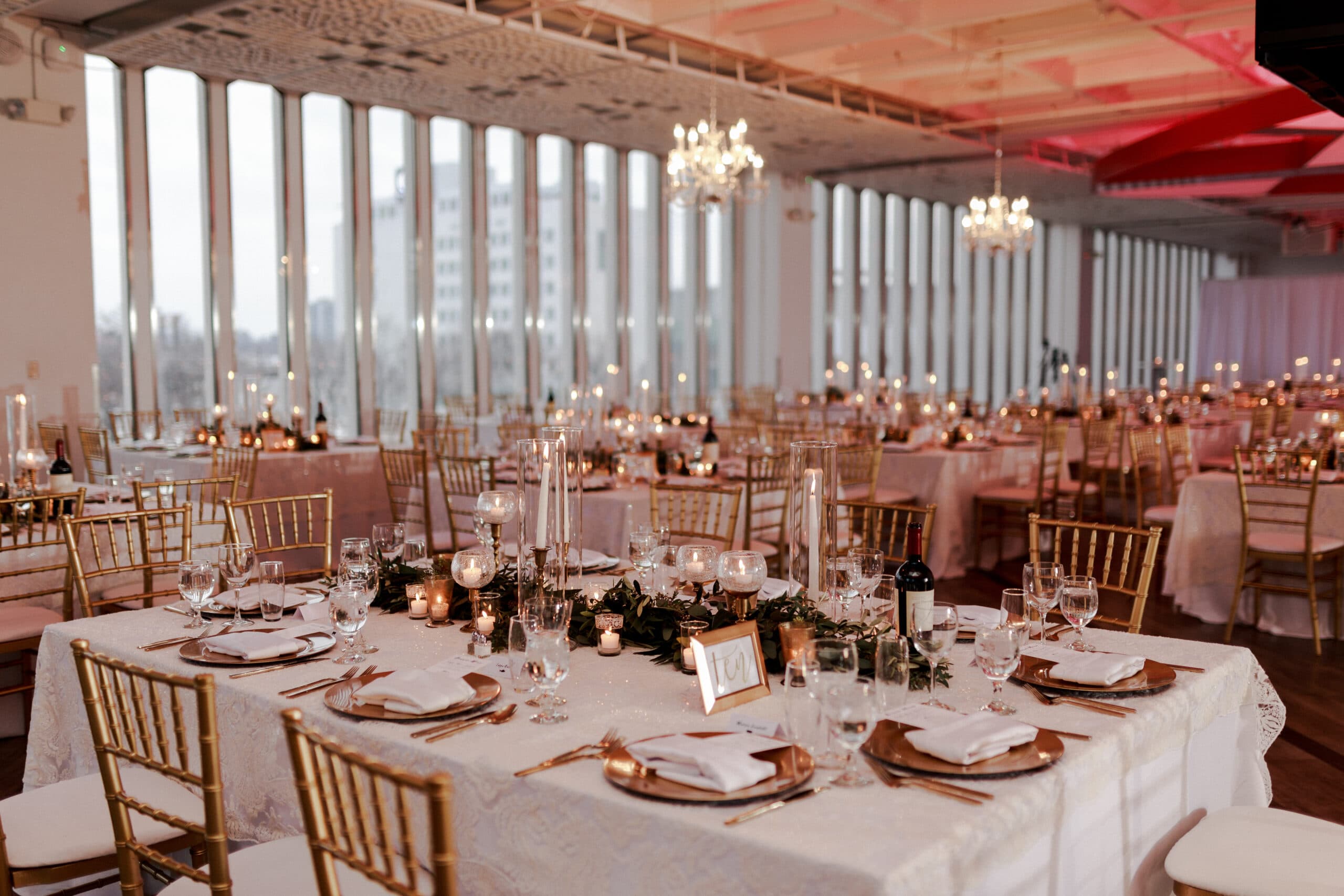 Wedding setup with floor to ceiling windows and chandeliers