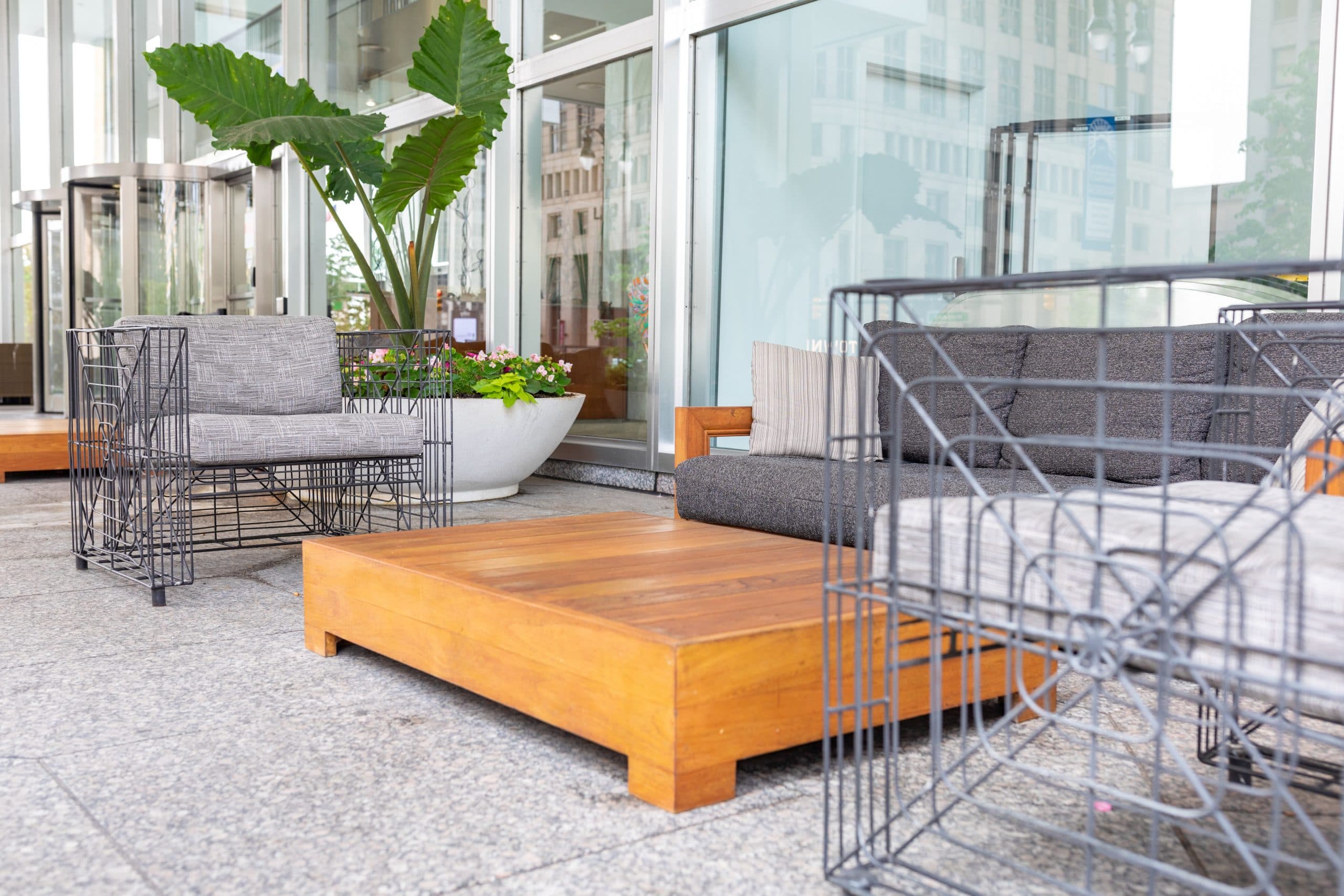 Chase Tower Lobby + Patio featuring a large live planter, and outdoor patio furniture and revolving doors to the indoor lobby space.